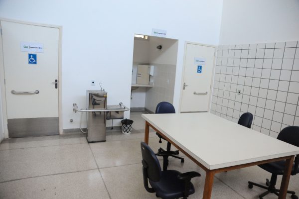 Oficina ortopédica com dois banheiros PCD, um bebedouro e uma mesa.